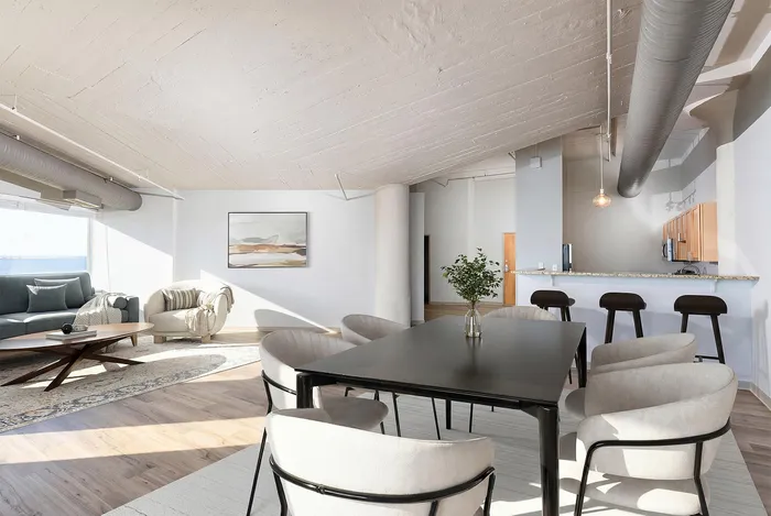 Modern loft-style apartment with open-concept living and dining area, sleek furniture, and an airy ambiance. Features a cozy seating area, a stylish dining table, and a chic breakfast bar under industrial accents.