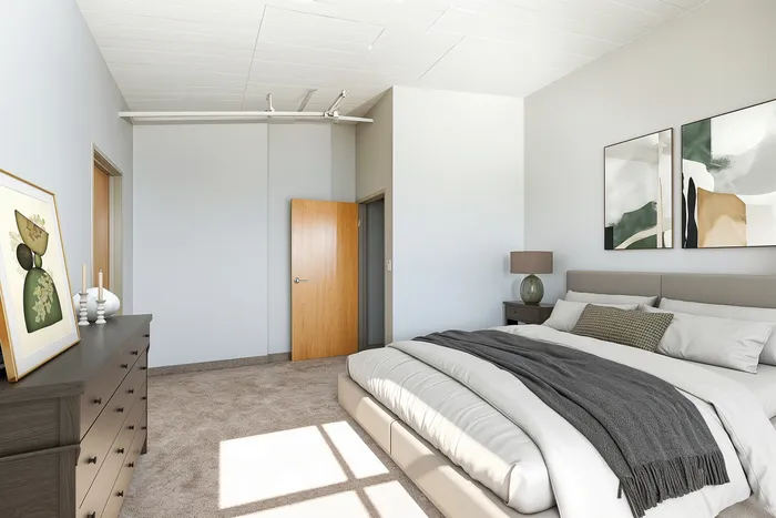 Modern bedroom showcasing elegant decor with cozy natural light, featuring chic artwork and plush bedding.