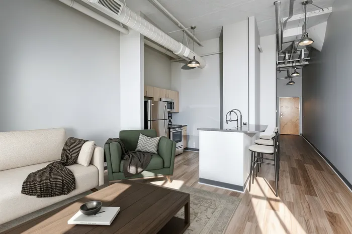 Chic modern apartment interior featuring an open-concept living area with cozy seating, a sleek kitchen with stainless steel appliances, and stylish pendant lighting.
