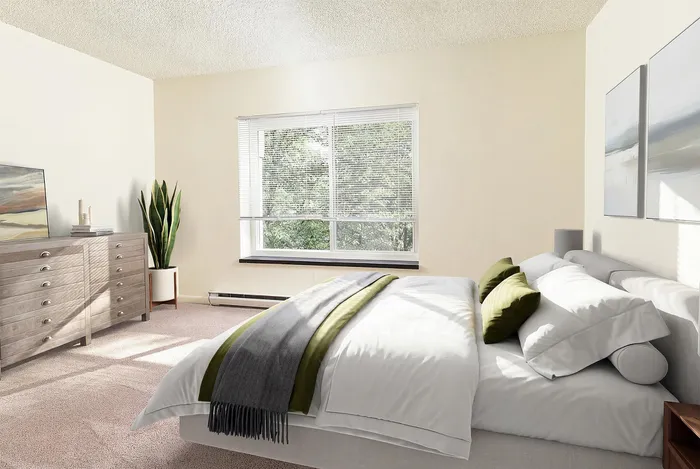 Bright and inviting bedroom with a large window, modern decor, and a cozy bed with green accents.