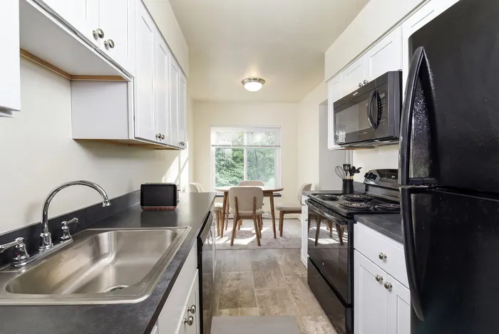 Bright and inviting kitchen with sleek countertops, modern appliances, and a cozy dining area with outdoor views.
