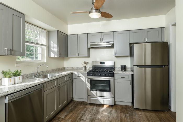Modern kitchen with sleek gray cabinetry, granite countertops, and stainless steel appliances for a sophisticated culinary experience.