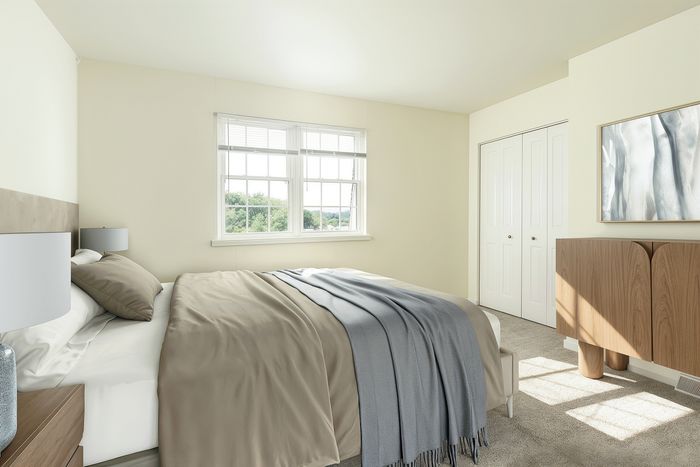 Bright and airy bedroom with a large window, elegant decor, and a cozy bed draped in soft linens.