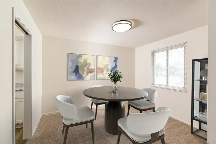 Bright and inviting dining area with modern round table, comfortable chairs, and contemporary art decor.