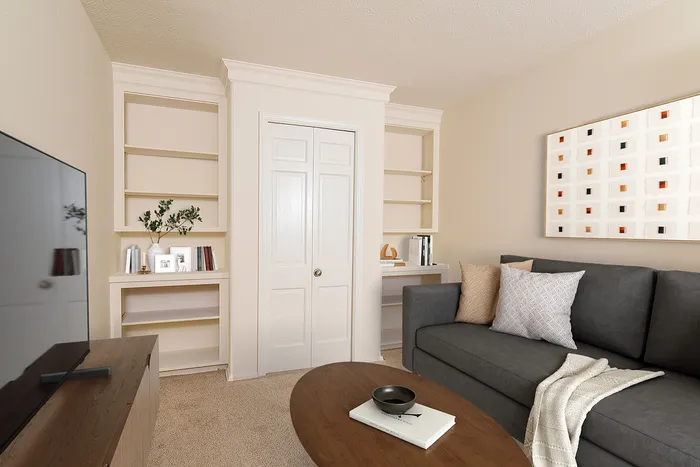 Charming living room featuring a modern gray sofa, elegant built-in shelves, and tasteful wall art, creating a cozy and inviting ambiance.