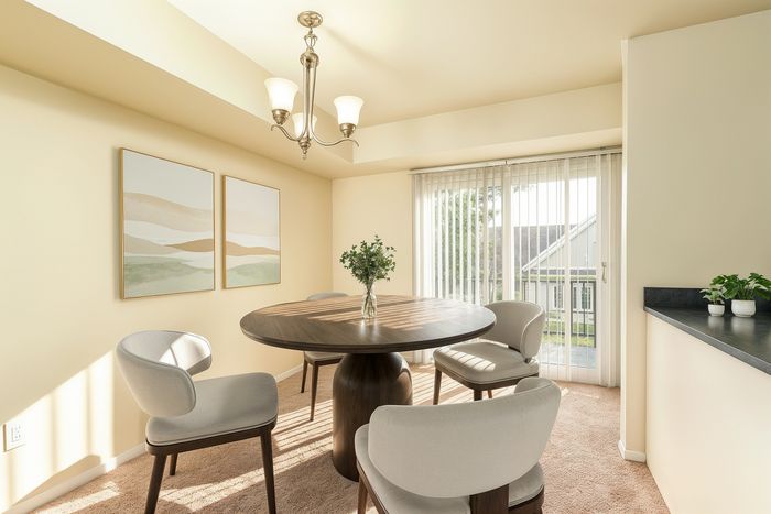 Bright dining area with elegant round table, modern chairs, and large windows offering ample natural light.