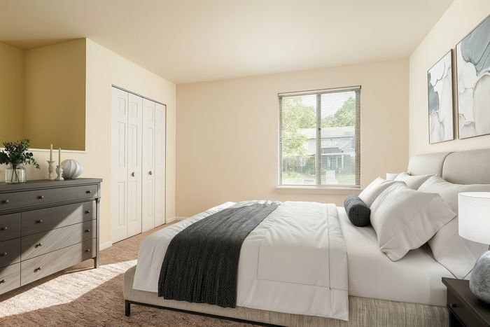 Bright and inviting bedroom with a plush bed, elegant decor, and a peaceful view through a large window.