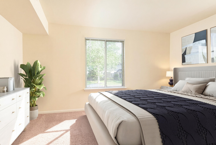 Bright and inviting bedroom with modern decor, featuring a large window, stylish bed, elegant dresser, and vibrant plant accent.