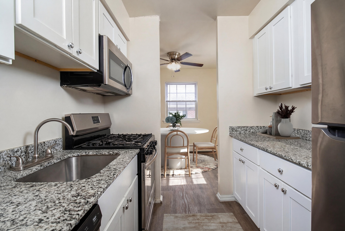 Chic kitchen showcasing modern stainless steel appliances, granite countertops, and a cozy dining nook with abundant natural light.