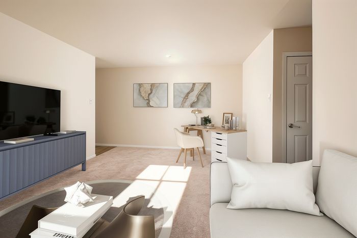 Chic modern living room with elegant beige decor, large flat-screen TV, stylish art pieces, cozy seating area, and a functional workspace, perfect for comfort and productivity.
