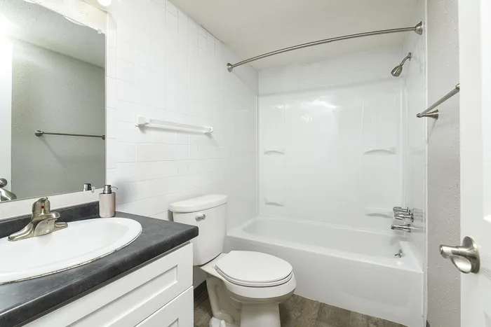 Bright and modern bathroom featuring a sleek white sink, contemporary fixtures, and a pristine bathtub.