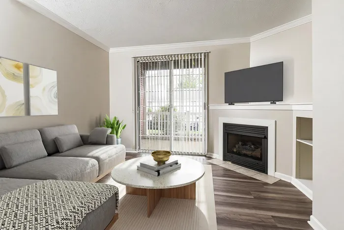 Contemporary living room with a cozy gray sectional, modern fireplace, and large windows offering abundant natural light.