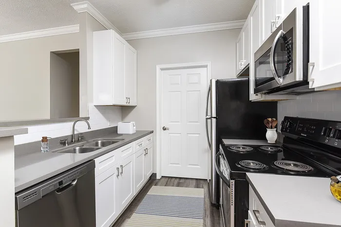 Modern kitchen with sleek stainless steel appliances, elegant white cabinetry, and stylish countertops.