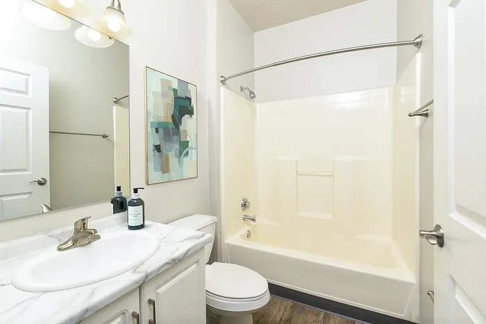 Elegant bathroom featuring a sleek marble countertop, modern fixtures, and contemporary artwork for a touch of luxury.