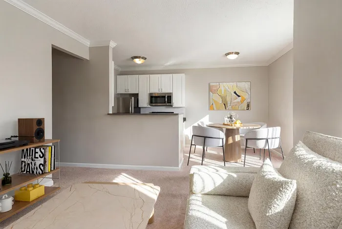 Bright and modern living space featuring a cozy seating area, elegant dining setup, and a sleek open kitchen with stylish cabinetry.