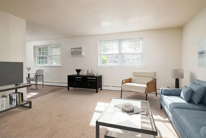Bright and airy living room with modern furnishings, large windows letting in natural light, and cozy seating arrangements.