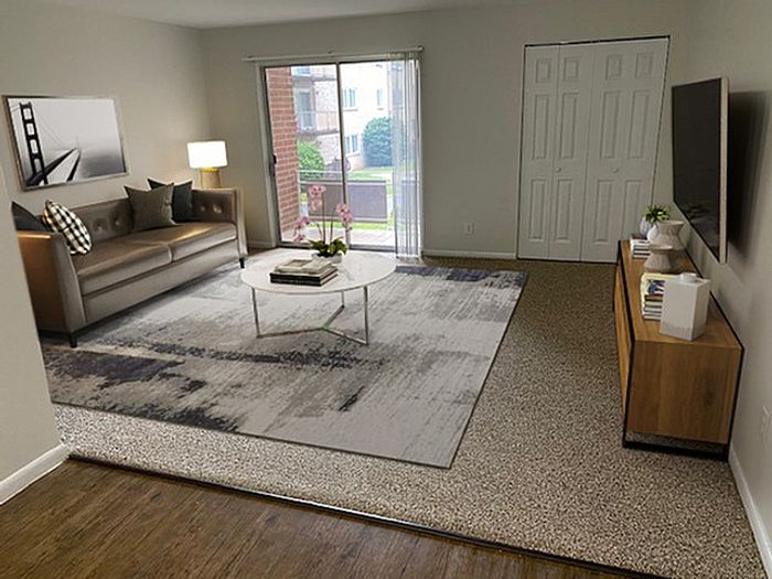 Bright and modern living room with a sleek sofa, chic coffee table, and large window offering a beautiful garden view.