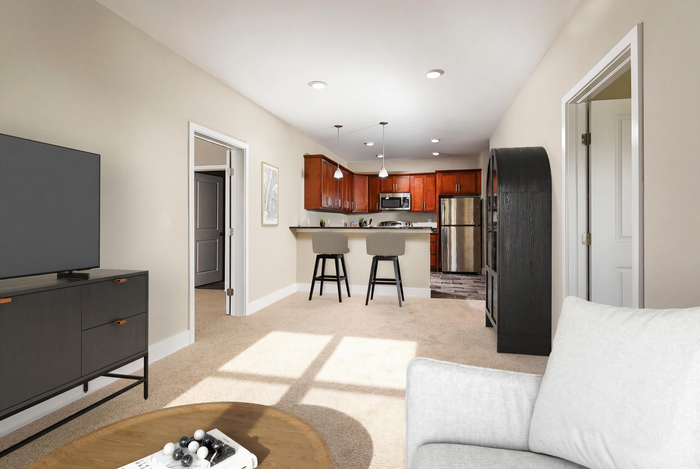 Modern apartment interior featuring an open-concept living area with a stylish kitchen and cozy seating, highlighted by warm natural light.
