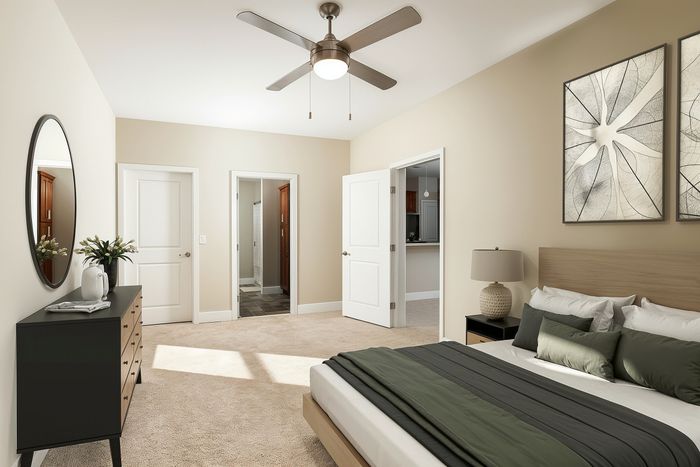Elegant bedroom with modern decor, plush carpet, and natural light, featuring a cozy bed, stylish artwork, and a sleek ceiling fan.