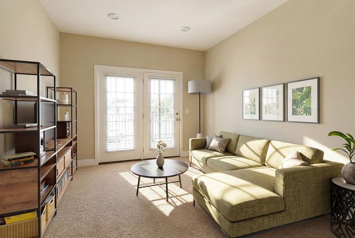 Inviting living room with a stylish green sectional sofa bathed in natural light, complemented by a modern bookshelf and elegant decor.