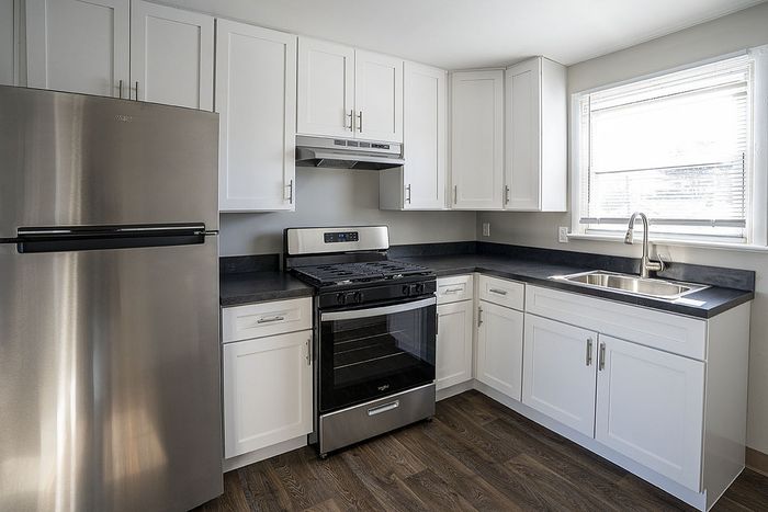 Modern kitchen with sleek stainless steel appliances, elegant white cabinetry, and bright natural light.