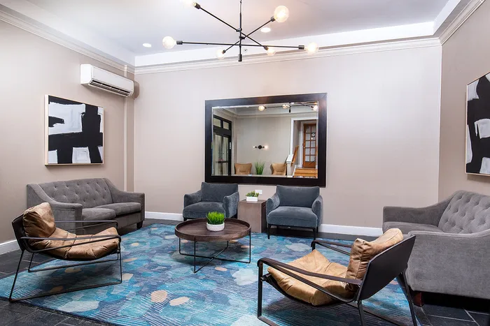 Contemporary living room with chic furniture, modern lighting, and stylish abstract art on soft neutral walls.