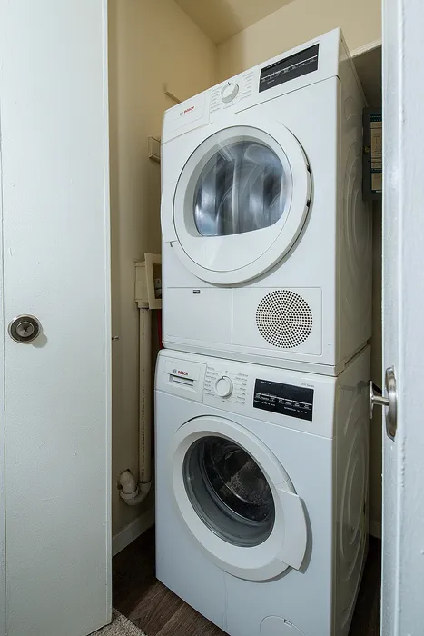 Modern laundry closet with sleek stackable washer and dryer for convenient in-home washing.