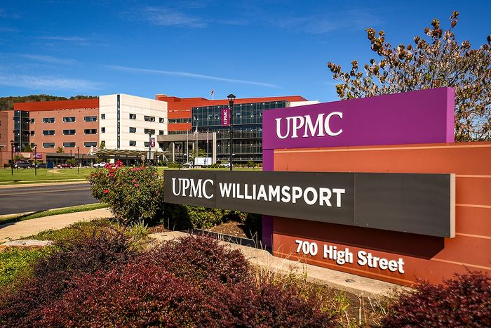 Vibrant exterior view of UPMC Williamsport with modern architecture and manicured landscaping under a clear blue sky.