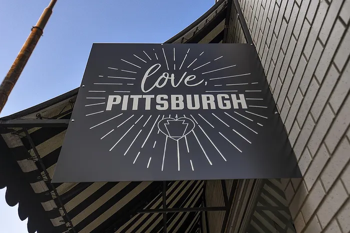 Chic urban signage reading 'Love, Pittsburgh' with a modern design and vibrant energy.