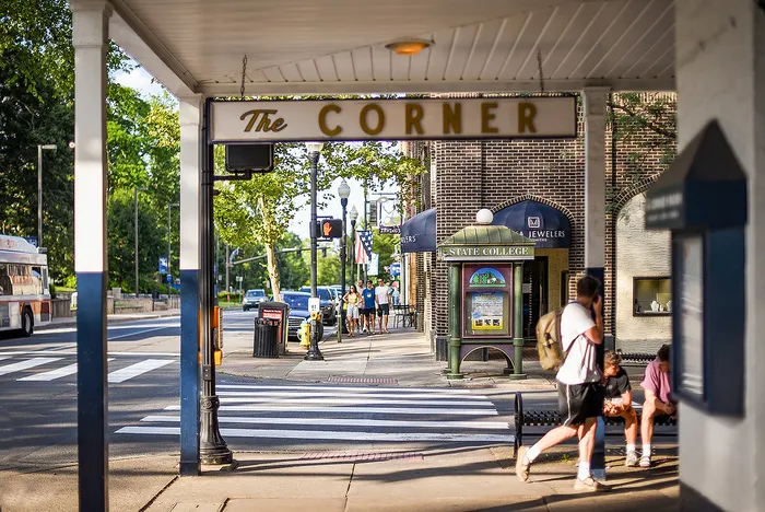 Charming street corner bustling with activity, featuring a bus stop, iconic signage, and vibrant urban atmosphere.