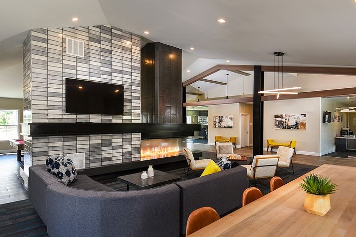 Luxurious open-concept living space featuring a modern fireplace, sleek furniture, and elegant lighting.