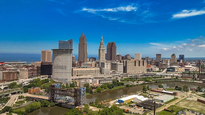Breathtaking cityscape showcasing a vibrant downtown skyline with modern skyscrapers under a clear blue sky, adjacent to a picturesque river.