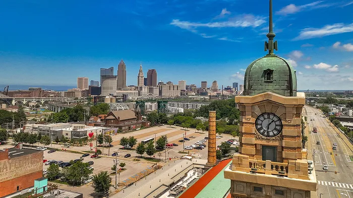 Stunning cityscape view showcasing a historic clock tower against a vibrant downtown skyline under a clear blue sky.