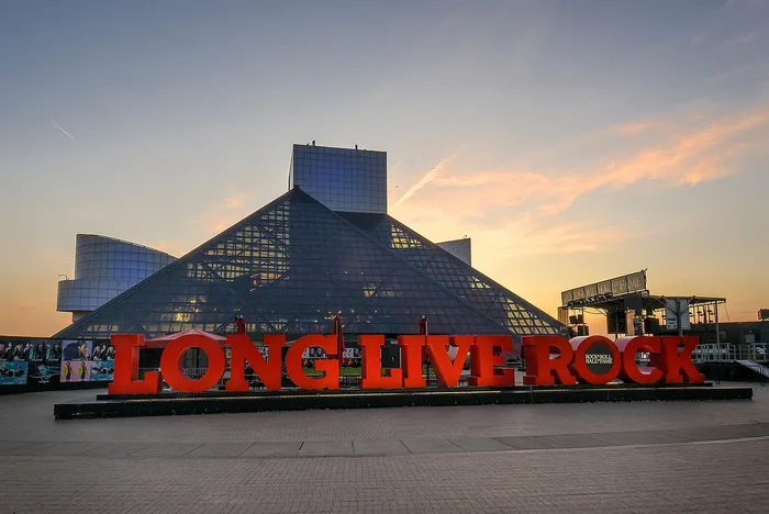 Dramatic architecture of iconic museum with bold 'Long Live Rock' sign at sunset.