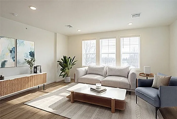 Bright and inviting living room with a cozy sofa, stylish armchair, and natural light streaming through large windows, complemented by elegant decor and hardwood floors.