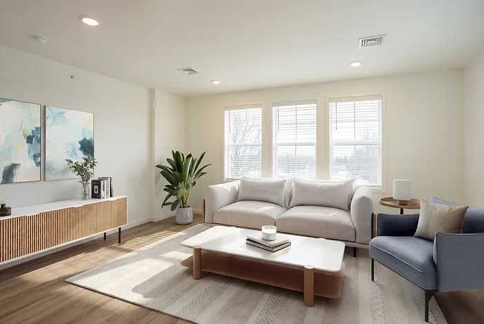 Bright and inviting living room with elegant decor, featuring a plush white sofa, stylish armchair, and natural wooden accents.