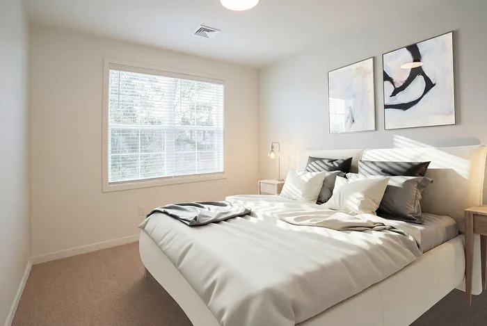 Bright and inviting bedroom with elegant decor and large window offering plenty of natural light.