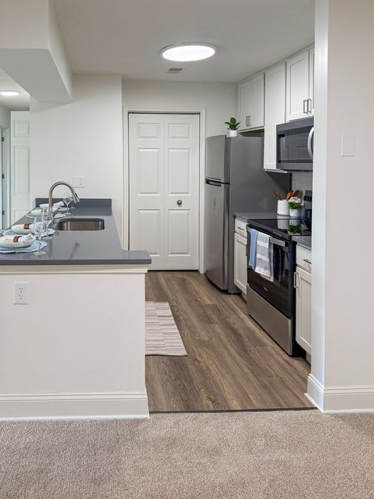 Modern kitchen with sleek countertops, stainless steel appliances, and elegant white cabinetry offering contemporary style and functionality.