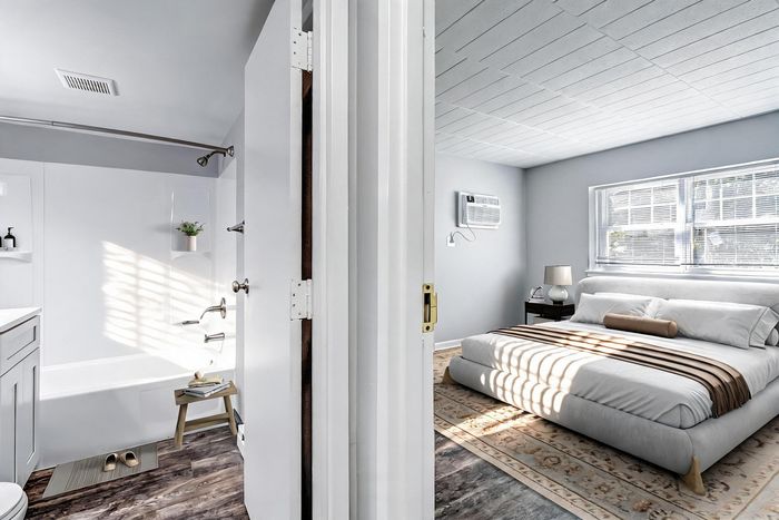 Bright bedroom with modern decor beside a sleek bathroom showcasing clean design and natural light.