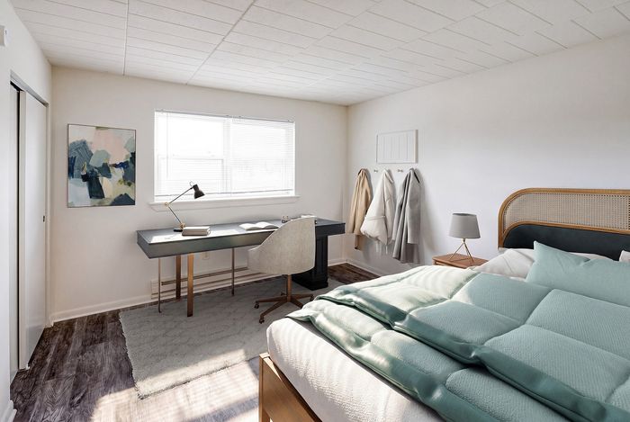 Bright and cozy bedroom with stylish desk, elegant decor, and luxurious bedding in a serene setting.