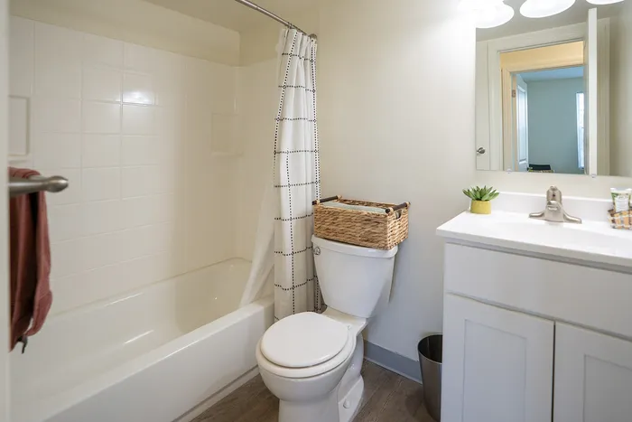 Bright and modern bathroom with elegant fixtures, featuring a sleek vanity, clean tilework, and a stylish shower curtain.