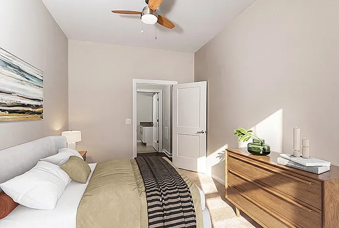 Bright and cozy bedroom featuring a stylish bed, modern wooden dresser, and elegant decor with natural light streaming in.