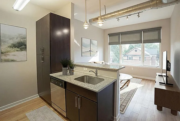 Chic open-concept apartment featuring a modern kitchen with stainless steel appliances, natural light-filled living area, and stylish industrial accents.