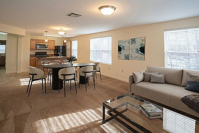 Inviting open-concept living and dining area with modern kitchen, stylish decor, and abundant natural light.