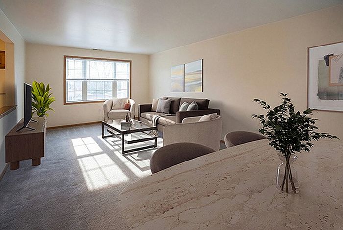 Bright, inviting living room with large window, modern decor, and cozy seating arrangement.