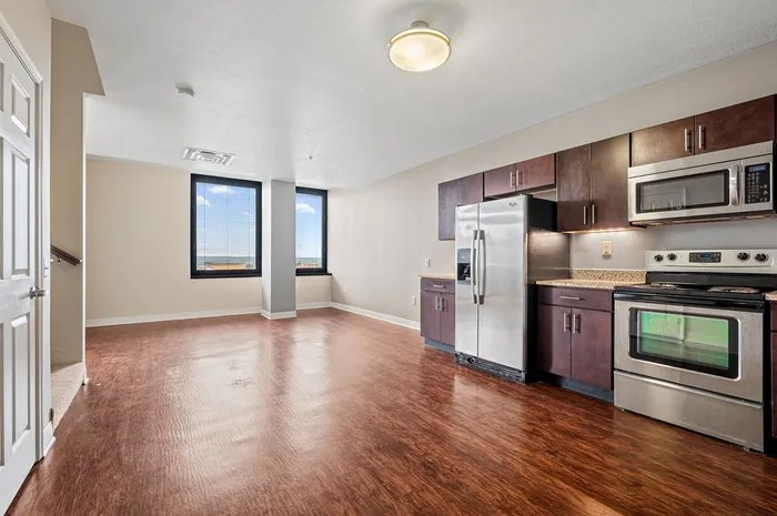 Bright and spacious open-concept kitchen with stainless steel appliances and large windows offering stunning views.