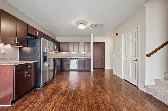 Spacious kitchen with sleek stainless steel appliances and elegant dark wood cabinetry, perfect for modern living.