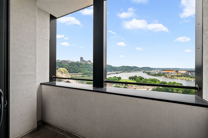 Stunning balcony view showcasing a vibrant cityscape with iconic bridges and a serene river.