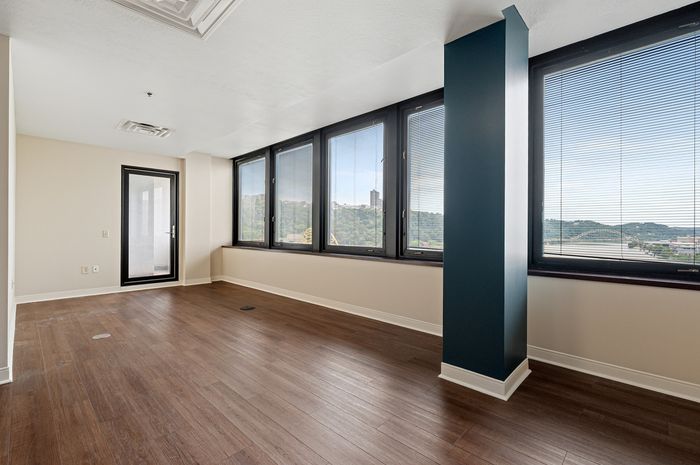 Bright and spacious room with large windows offering stunning panoramic views, welcoming ample natural light.