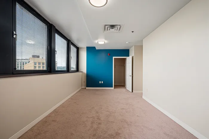 Bright and airy room with large windows, modern lighting, and a stylish blue accent wall, perfect for a home office or studio.